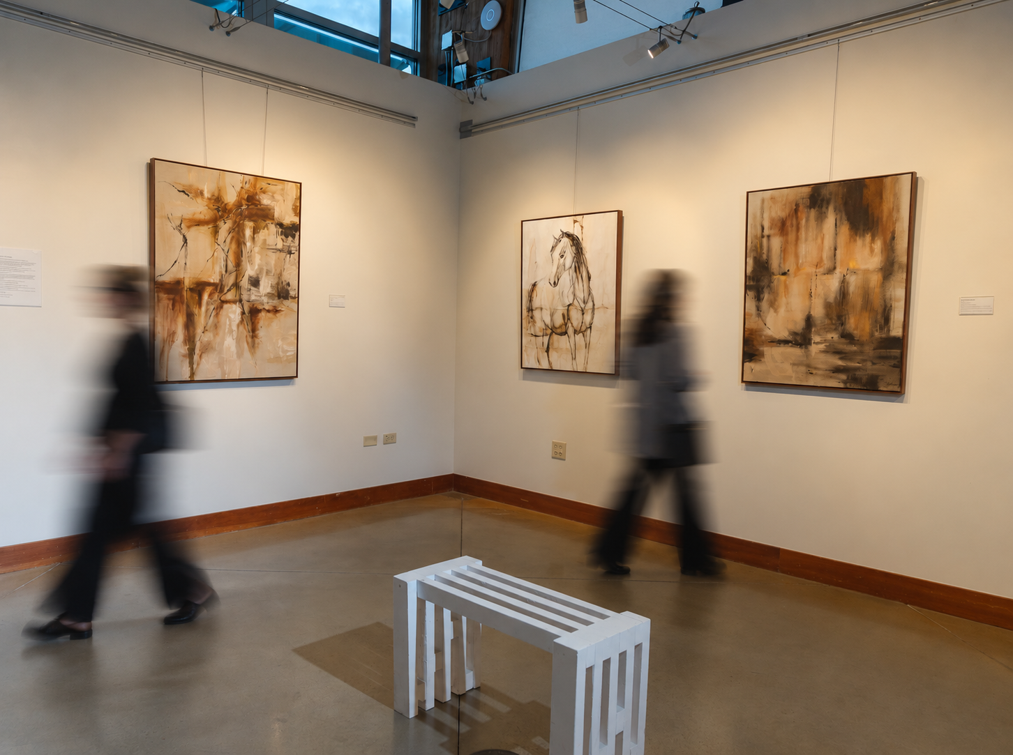 Becoming Home paintings installed at Art Gym Denver, with visitors in motion.